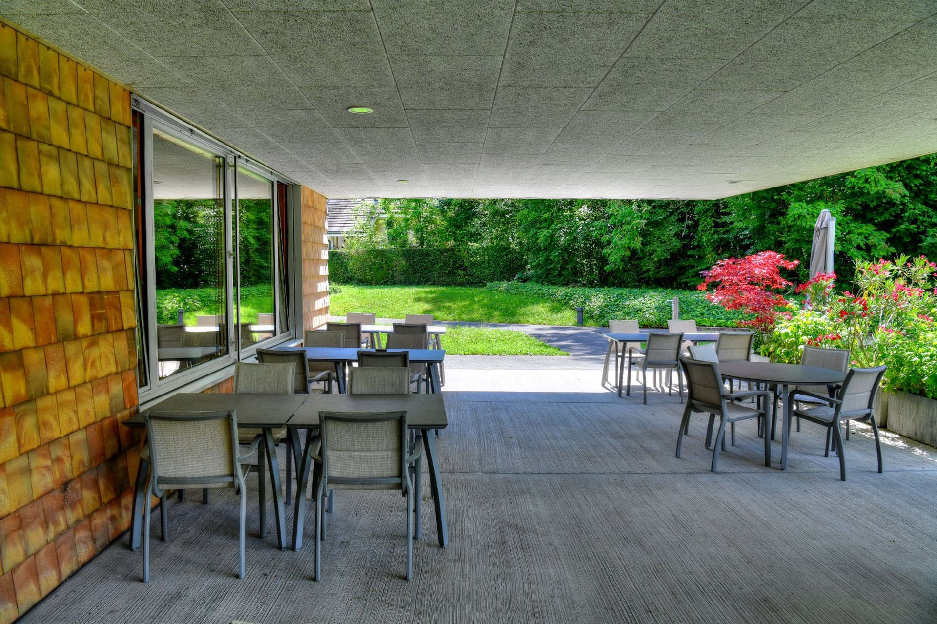 Un patio avec des tables et des chaises devant un bâtiment