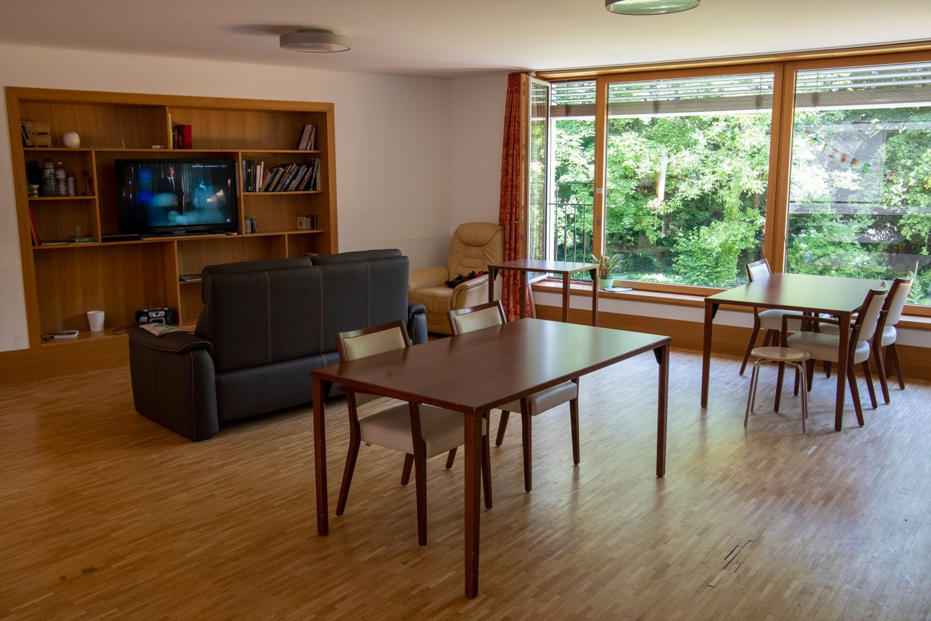 Un salon avec un canapé, une table, des chaises et une télévision.