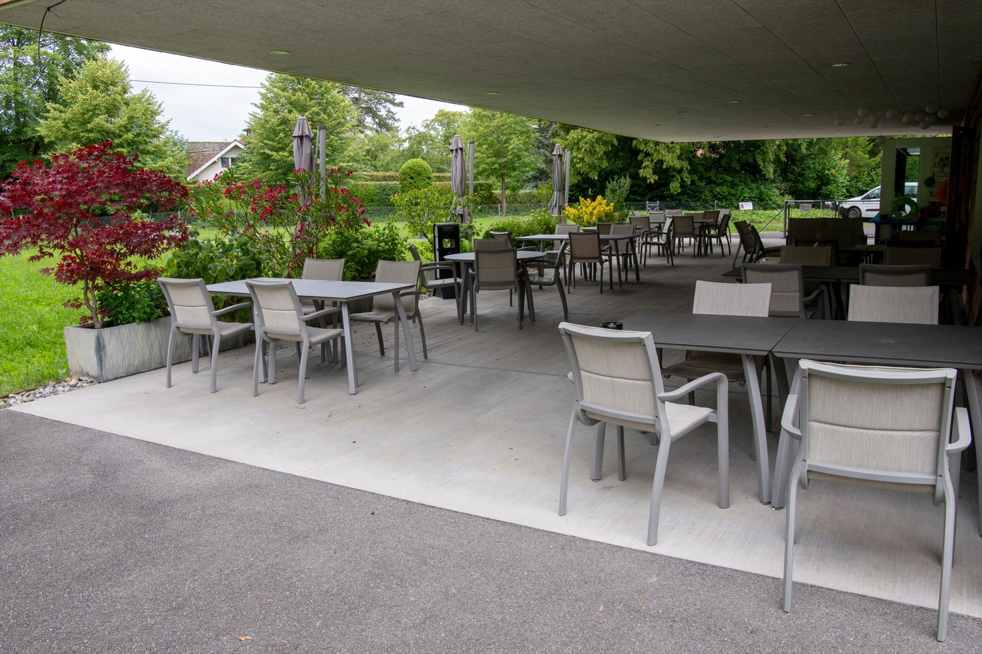 Un patio avec tables et chaises sous un auvent.