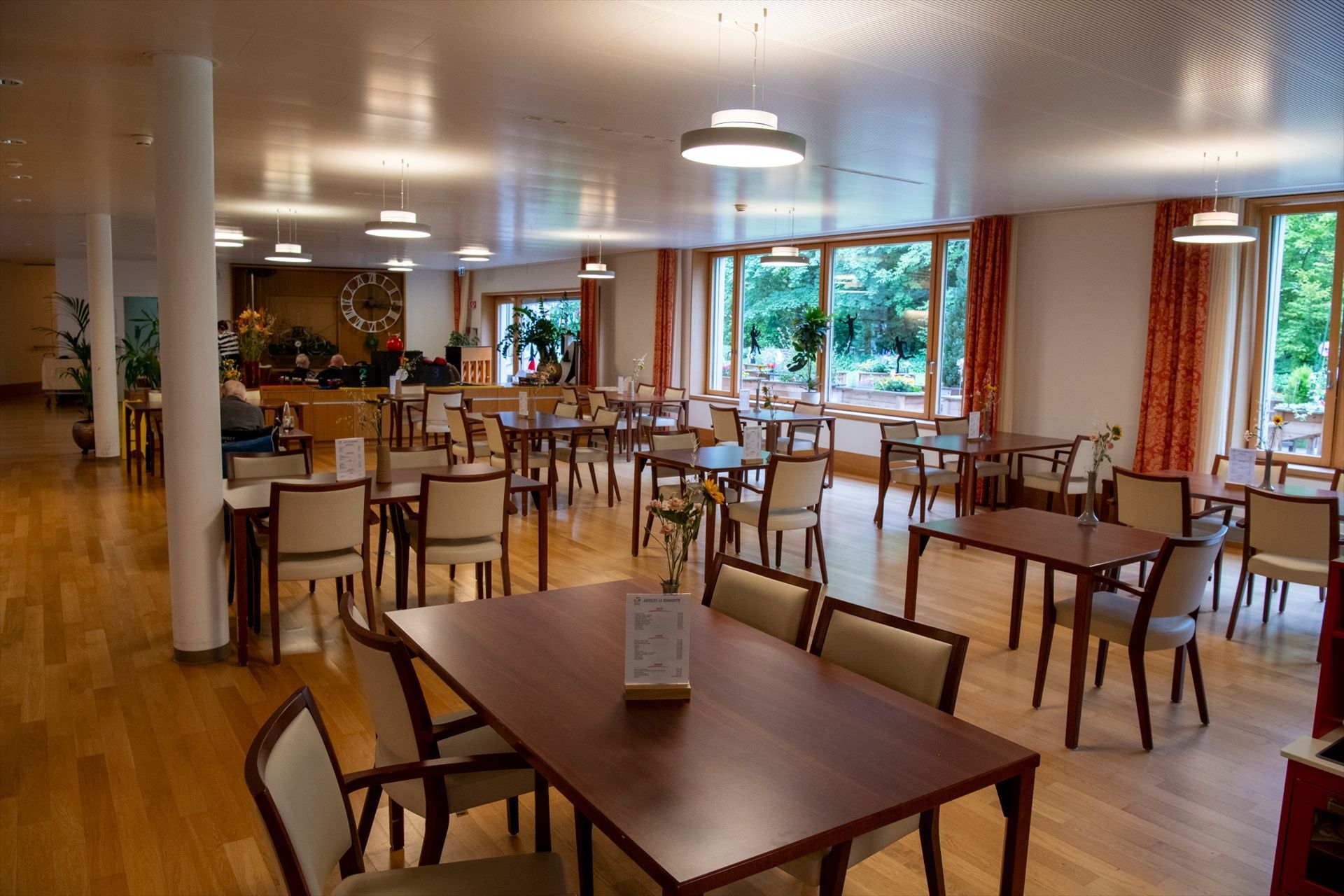 Il y a beaucoup de tables et de chaises dans cette grande pièce.