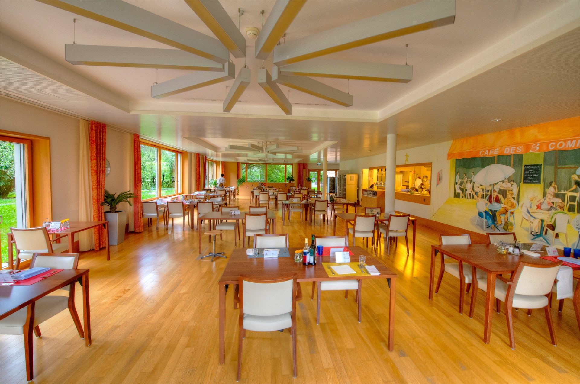 Une grande salle à manger avec tables et chaises et un ventilateur de plafond.