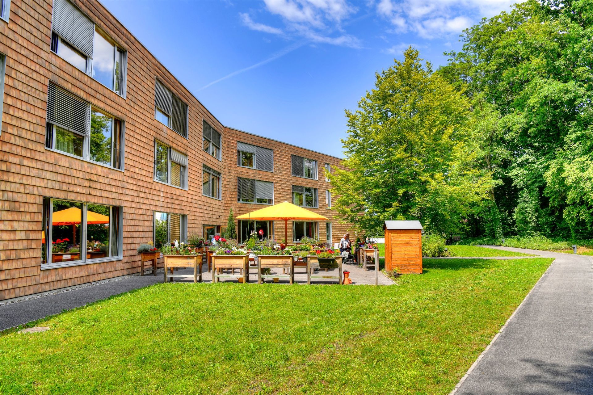 Un grand bâtiment en briques avec un parapluie jaune devant lui