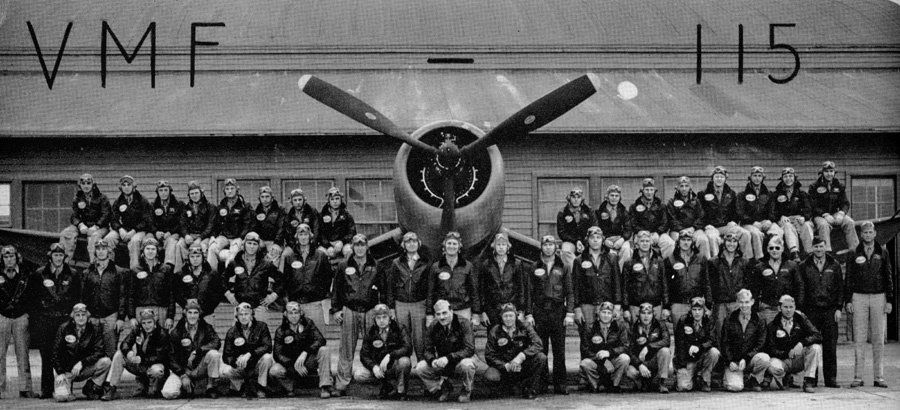 Group photo of Marine Corps pilots in front of an airplane. VMF-115 is printed above.