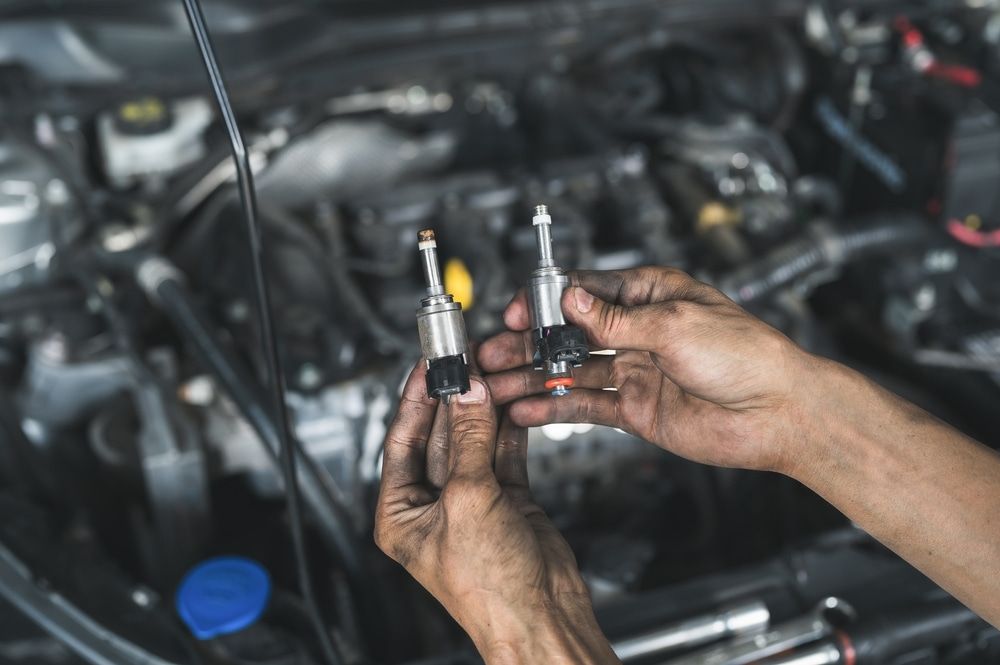 A Close Up of a Person Holding Two Lights in Front of a Car Engine — ANI Automotive in Long Jetty, NSW