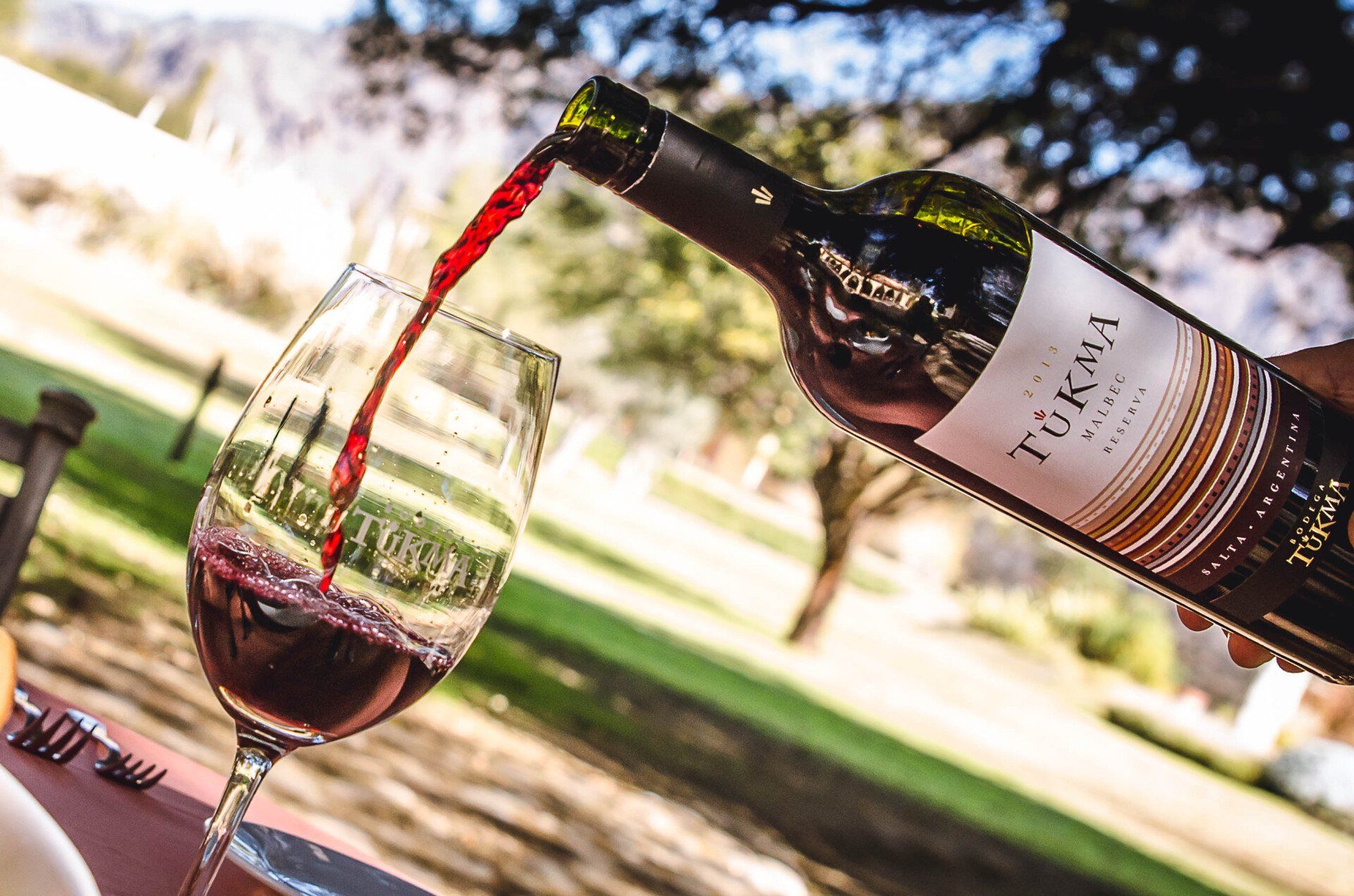 Se vierte una botella de vino en un vaso.