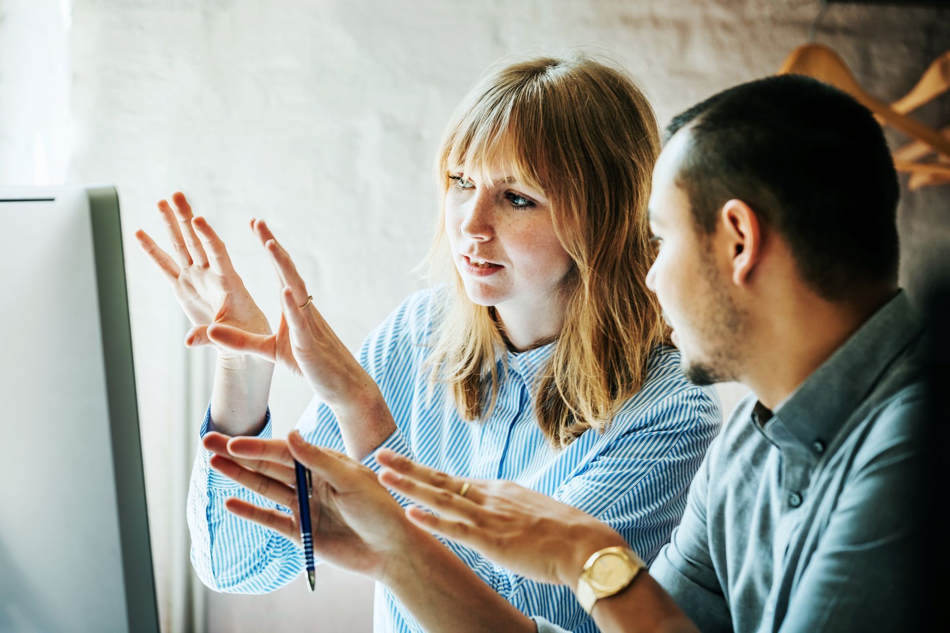 A man and a woman are looking at a computer screen together.