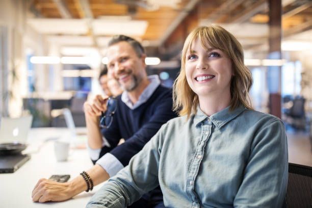 A group of people are sitting at a table in an office.