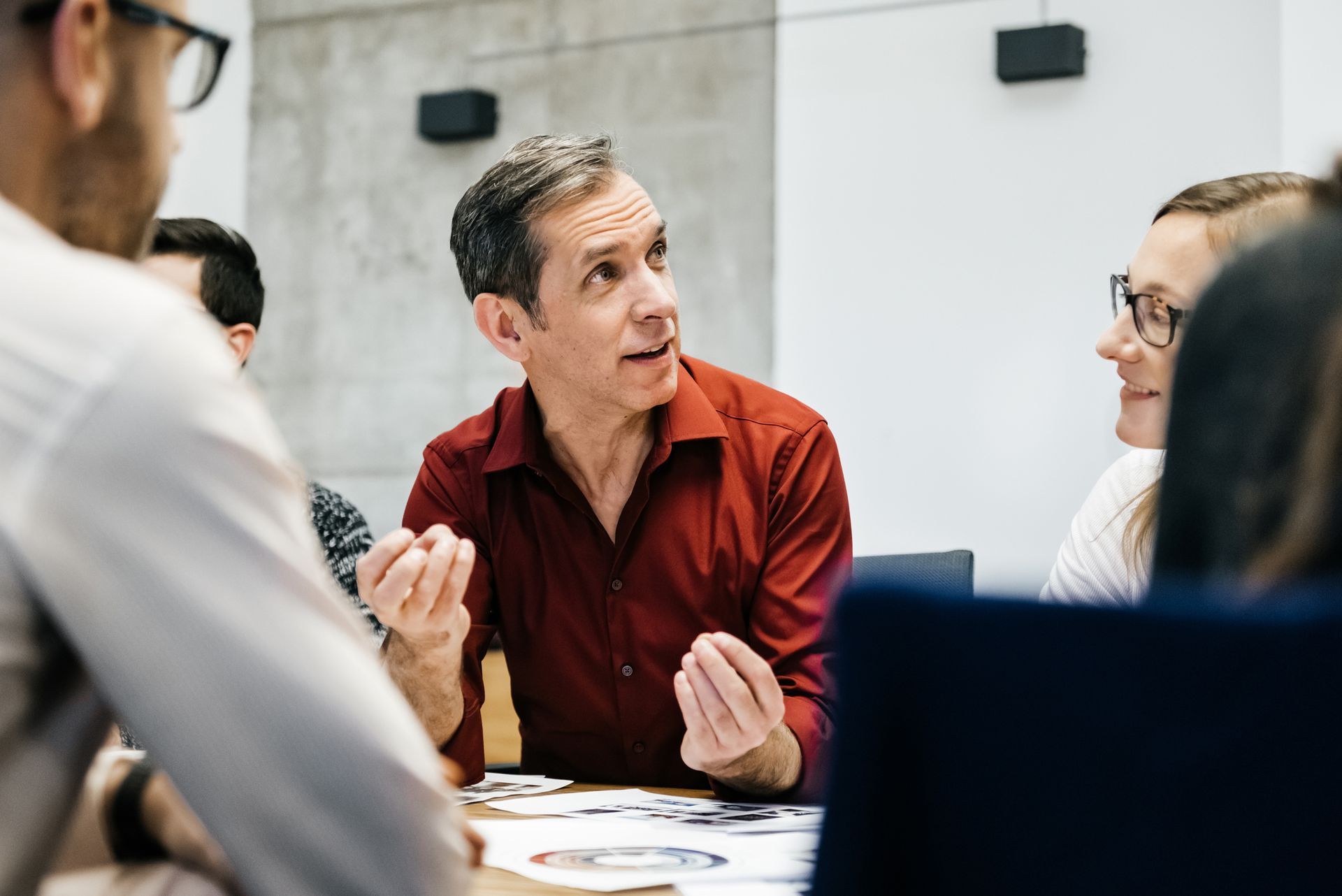 A group of people are sitting around a table having a meeting.