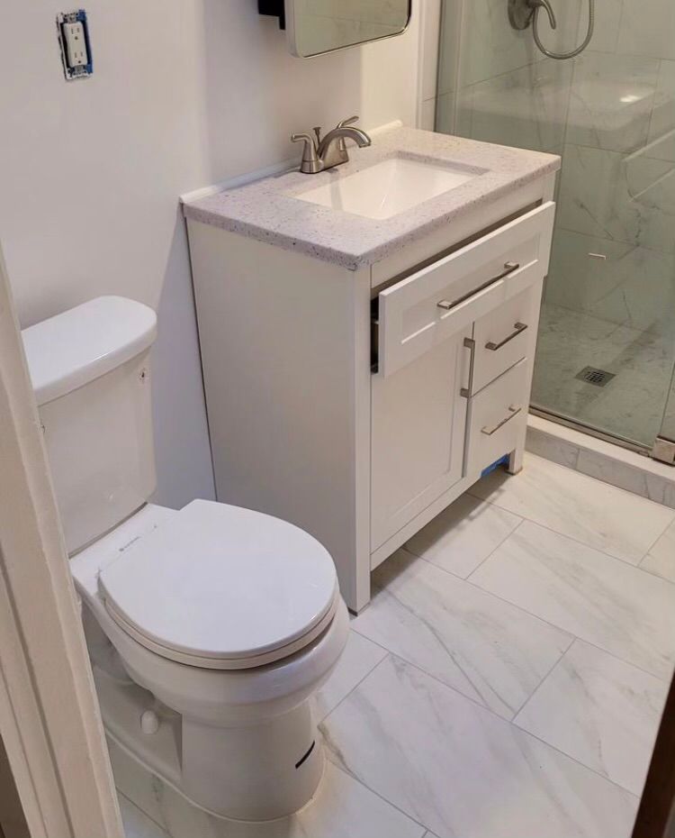 A bathroom with a toilet a sink and a shower