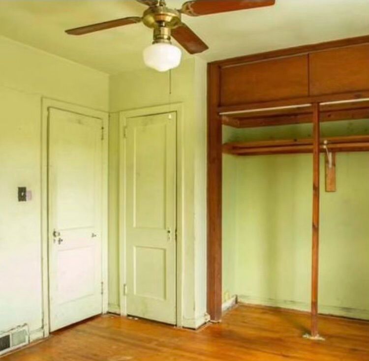 An empty room with a ceiling fan hanging from the ceiling