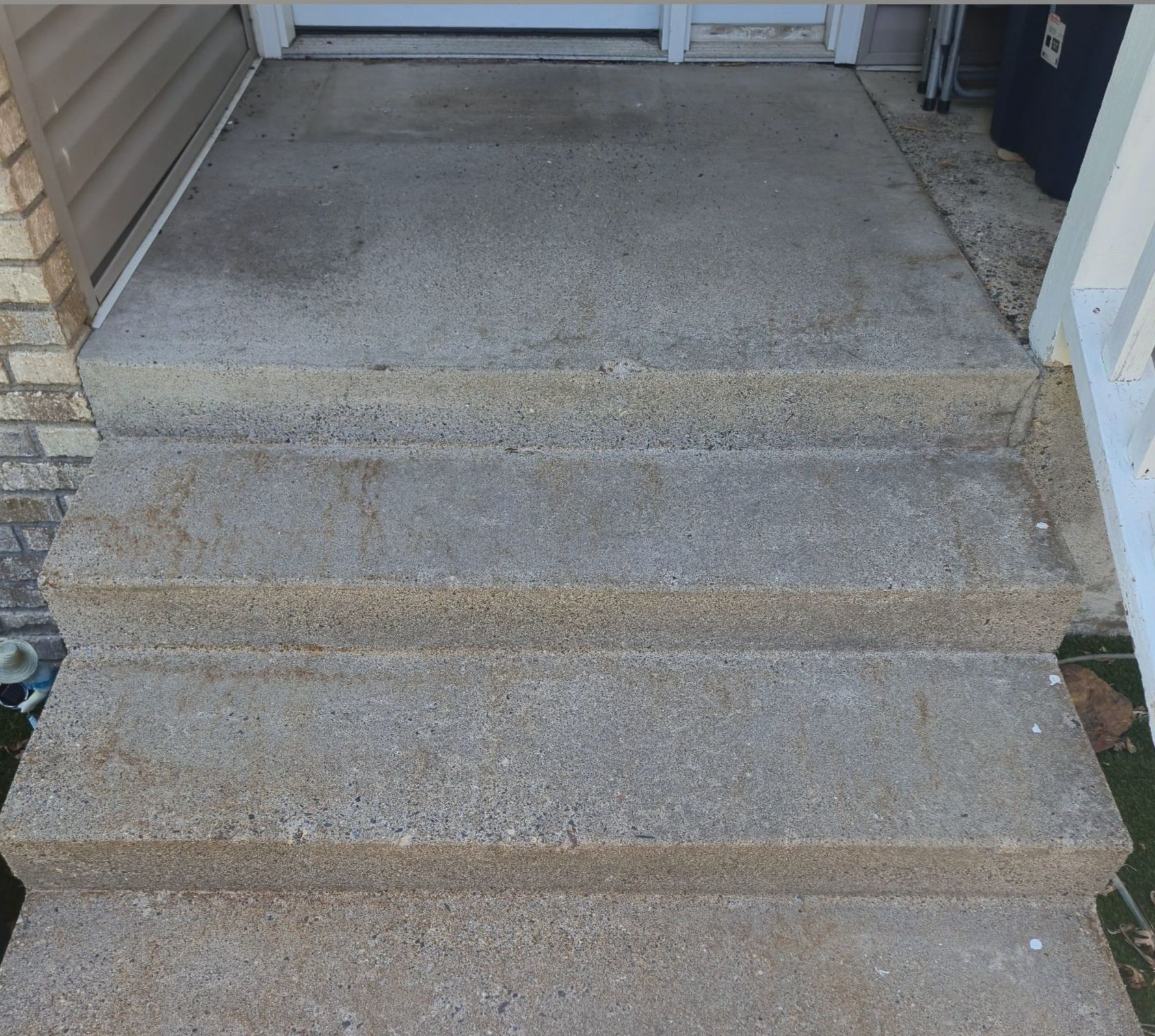 Concrete steps leading up to a doorway. The steps are gray and textured.