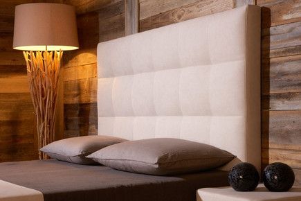 Ein Bett mit zwei Kissen und einem weißem Kopfteil.