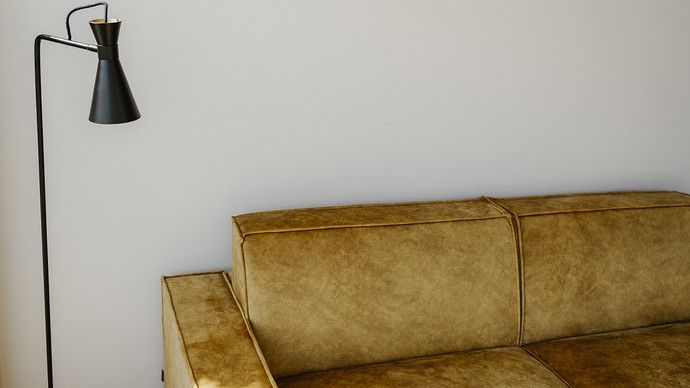 Eine Lampe steht neben einem Sofa in einem Wohnzimmer.