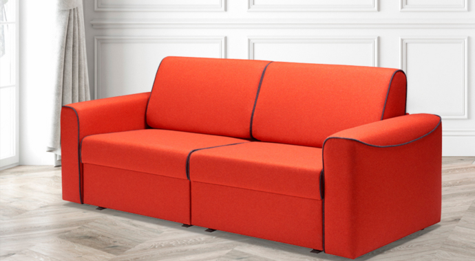 Ein rotes ausziehbares Sofa mit schwarzen Nähten auf weißem Hintergrund