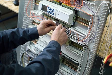 a technician working on the wiring of a building management system