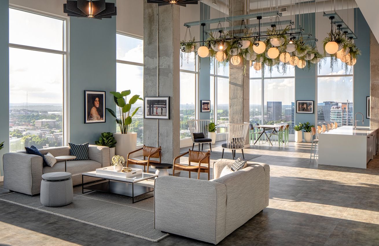 A living room with a lot of furniture and a lot of windows.