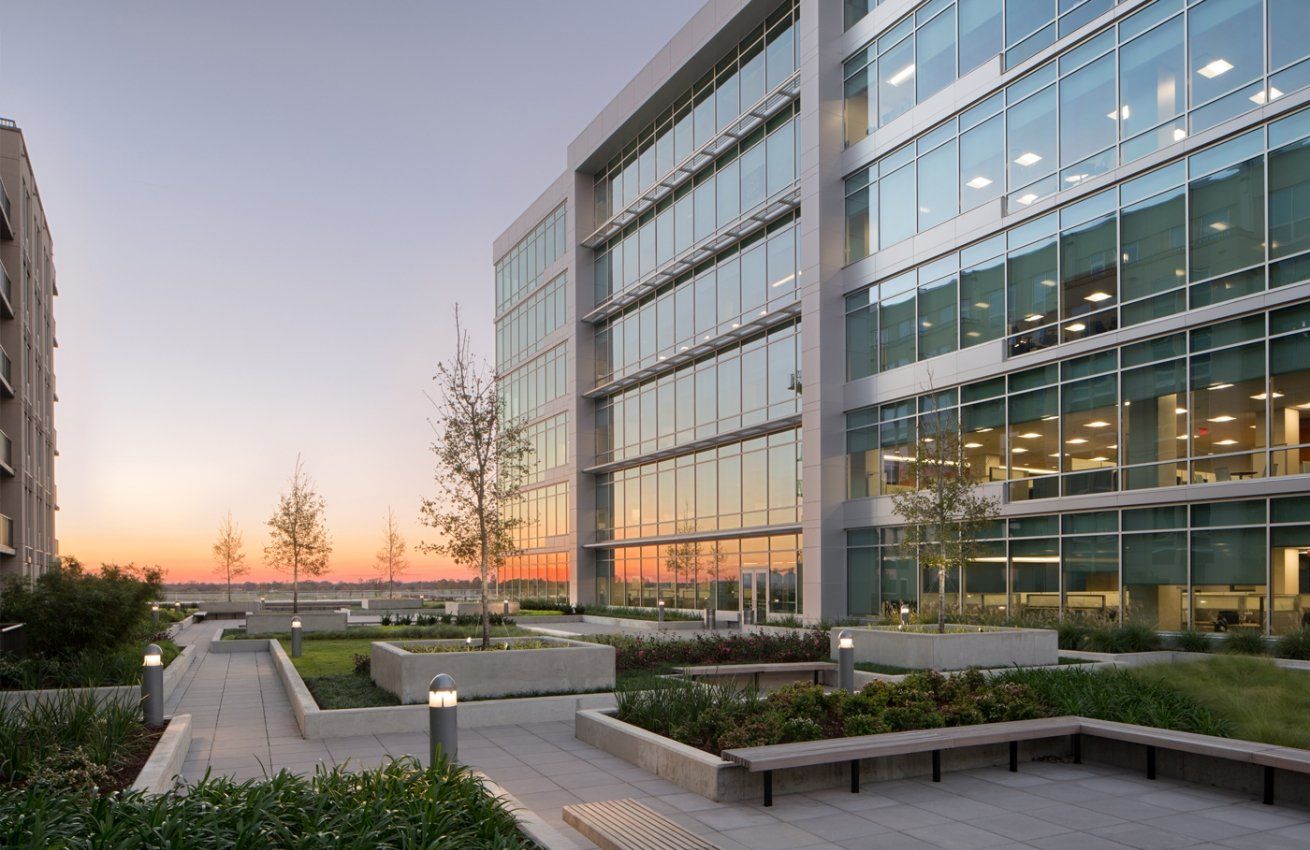 A large building with a lot of windows and a sunset in the background