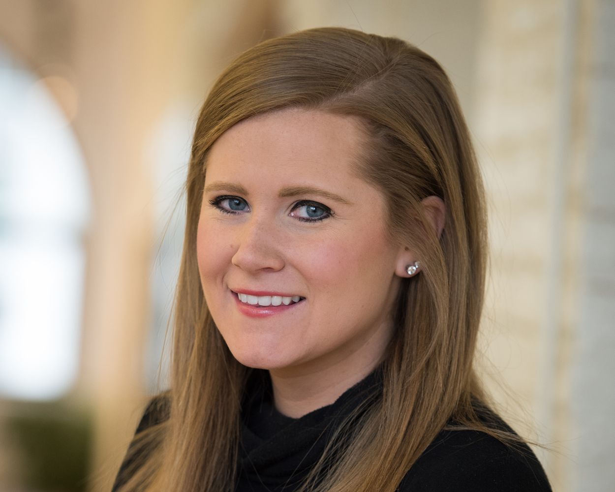 A woman in a black sweater is smiling for the camera.