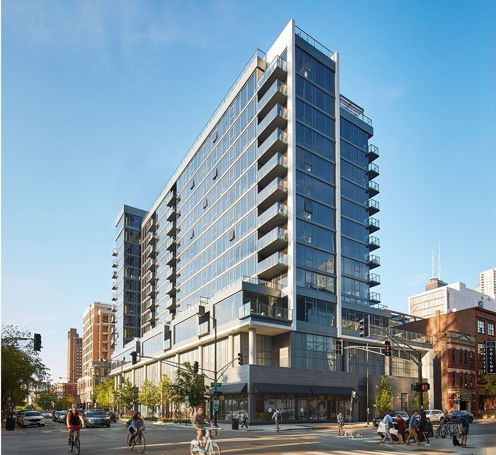 A large building with a lot of windows is in the middle of a city