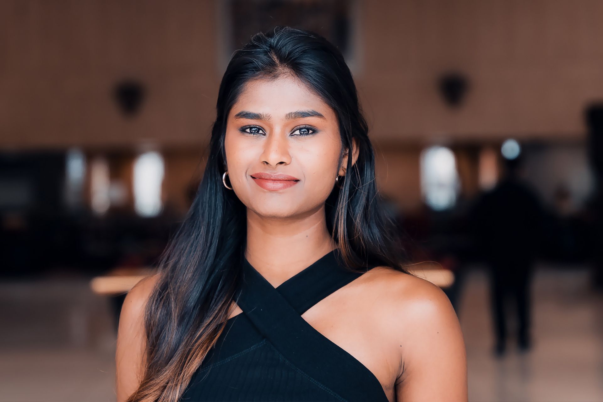 A woman in a black dress is smiling for the camera.