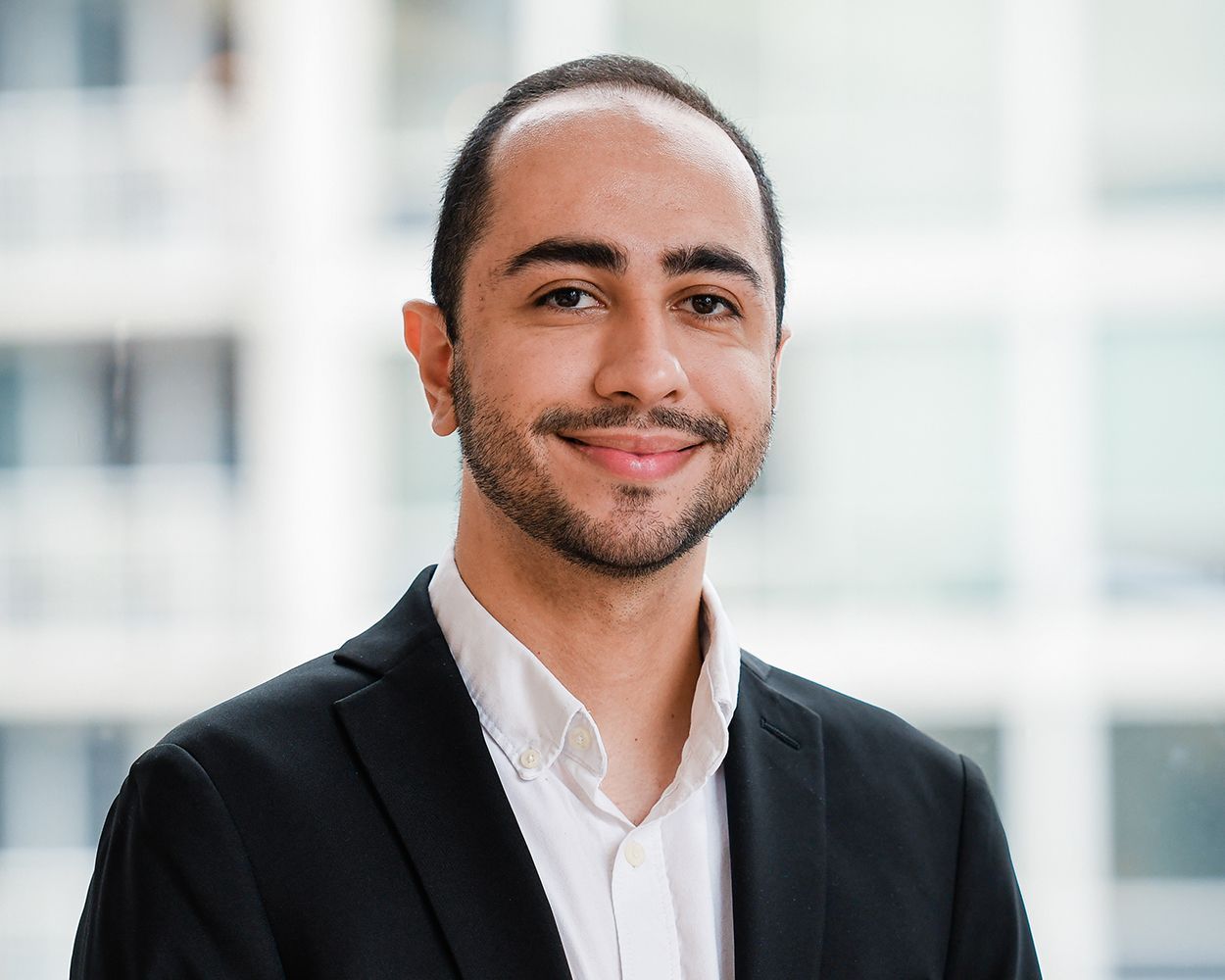 A man in a suit and white shirt is smiling for the camera.