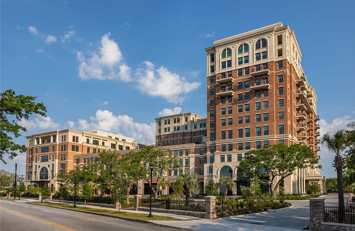 A large building with a lot of windows is sitting next to a street.