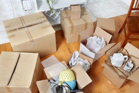 A Bunch Of Cardboard Boxes Are Sitting On The Floor In A Living Room — Removalists On The Gold Coast