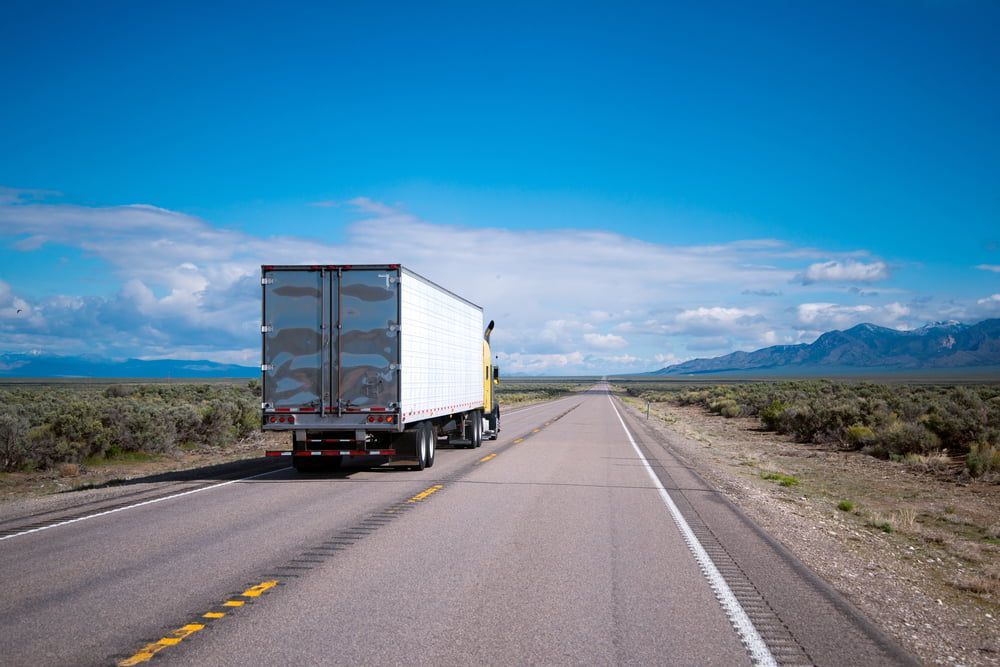A Semi Truck Is Driving Down A Highway In The Desert — Removalists On The Gold Coast