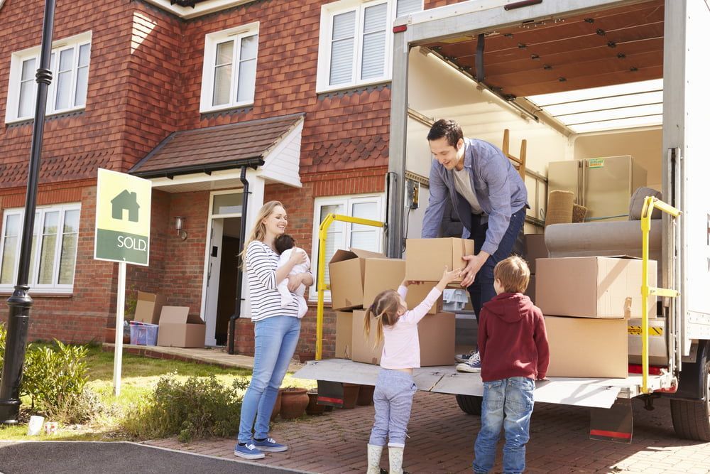A Family Is Loading Boxes Into A Moving Truck — Removalists In Lismore