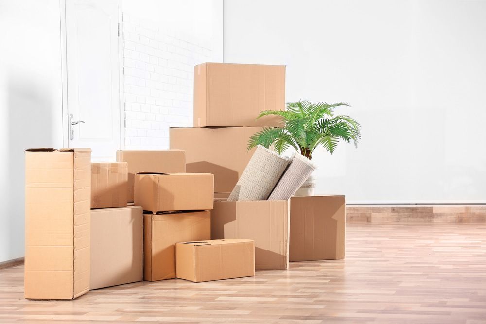 A Pile Of Cardboard Boxes Stacked On Top Of Each Other In An Empty Room — Removalist In Yamba