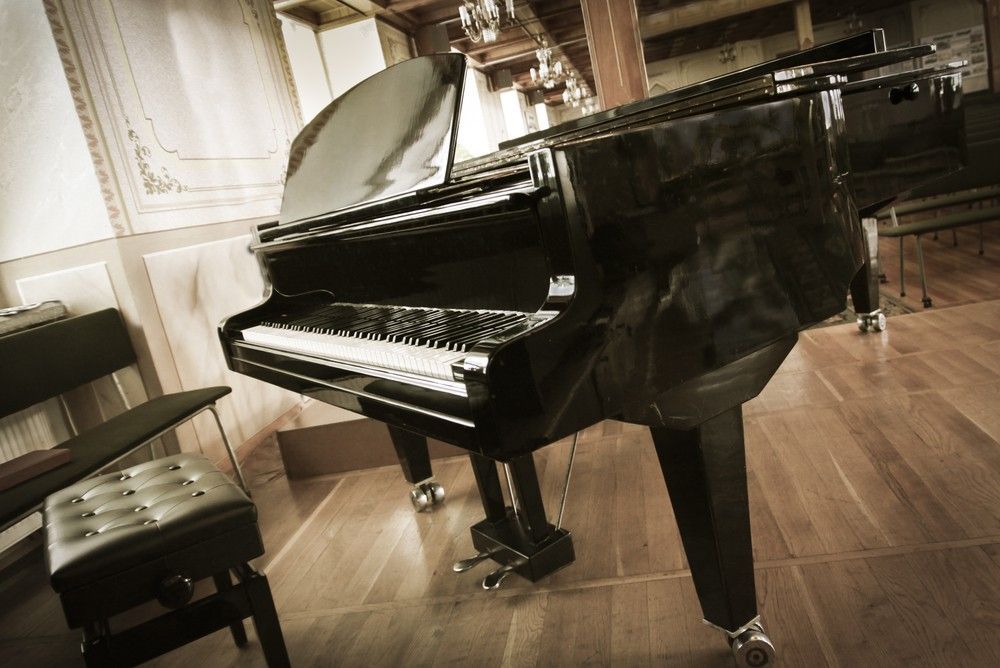 A Piano Is Sitting On A Wooden Floor In A Room — Removalists In Ballina