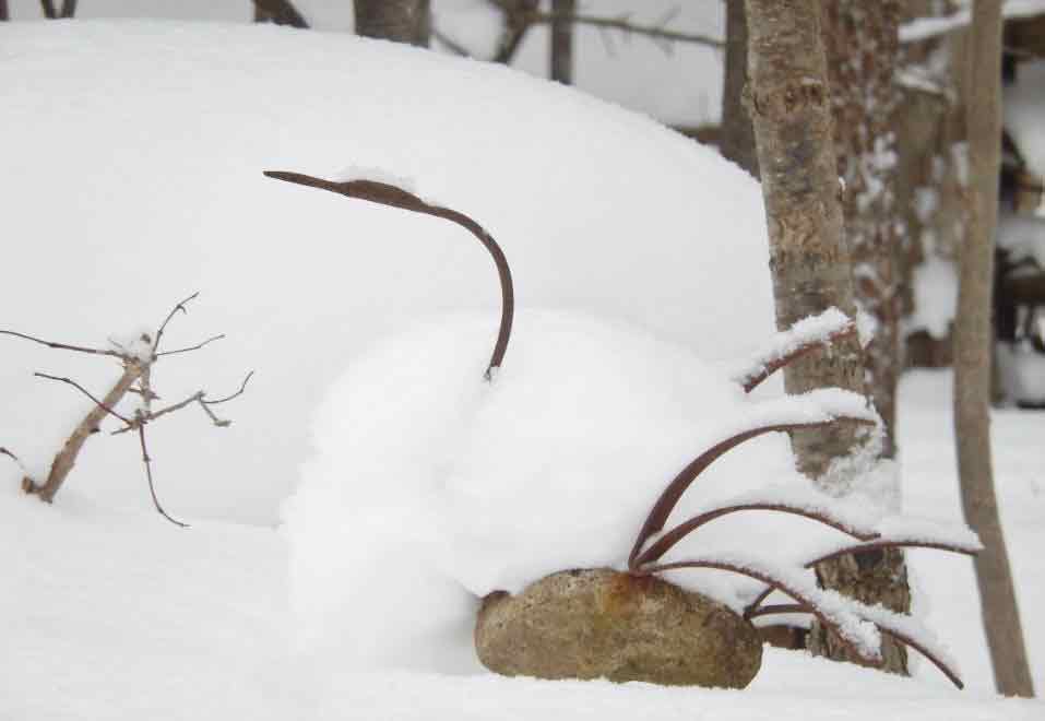 Snow on the ground and a metal sculpture