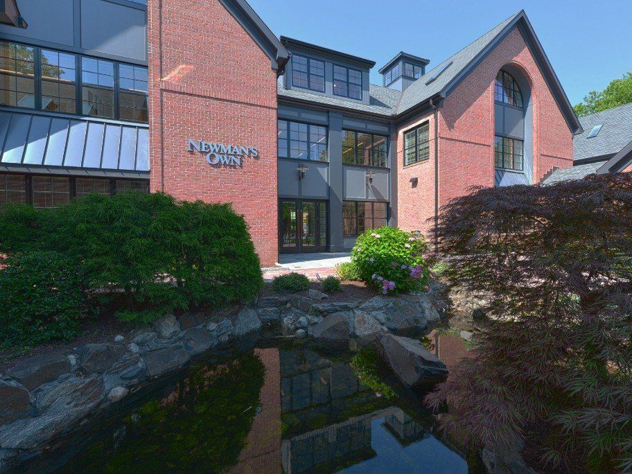 a large red brick building with a pond in front of it