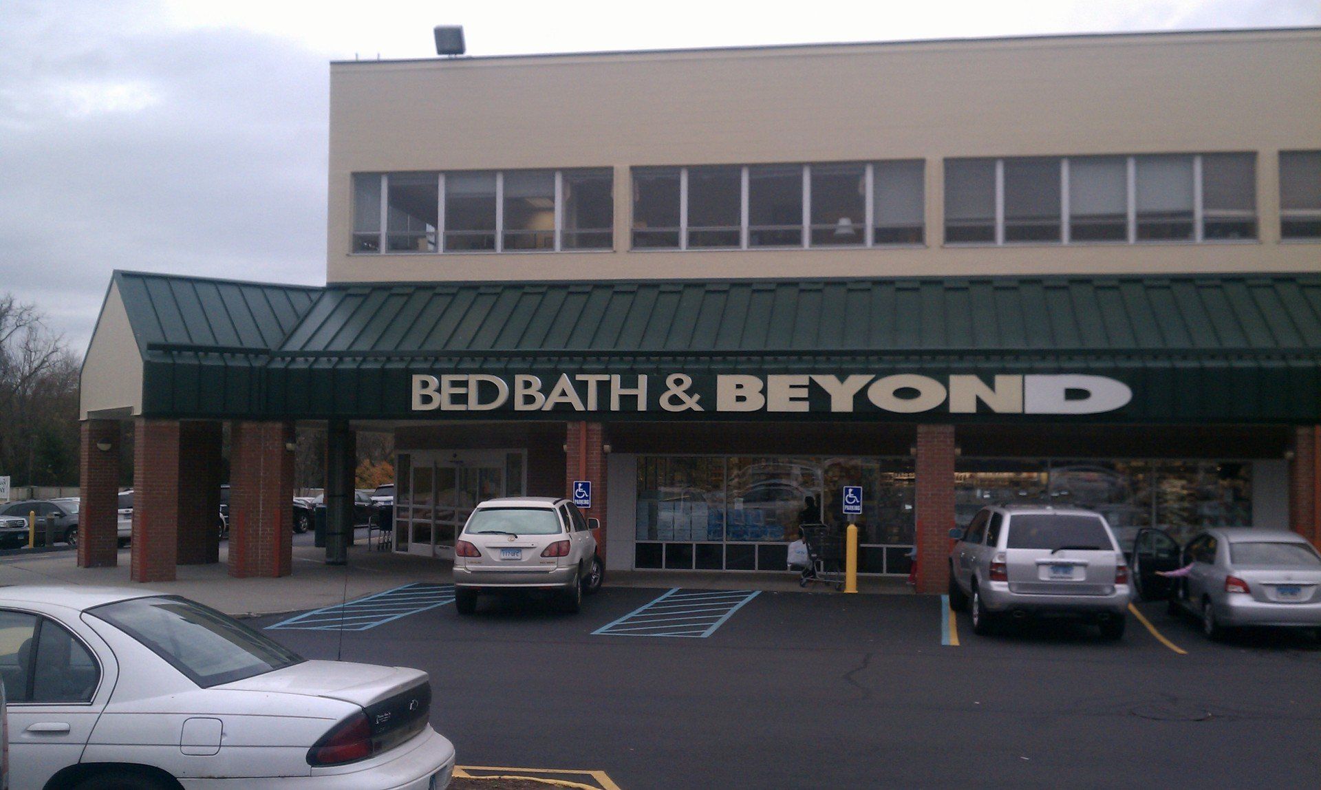 a bed bath and beyond store with cars parked in front of it