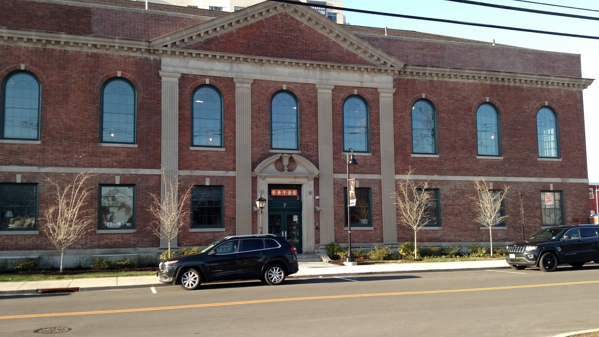 a black suv is parked in front of a large brick building