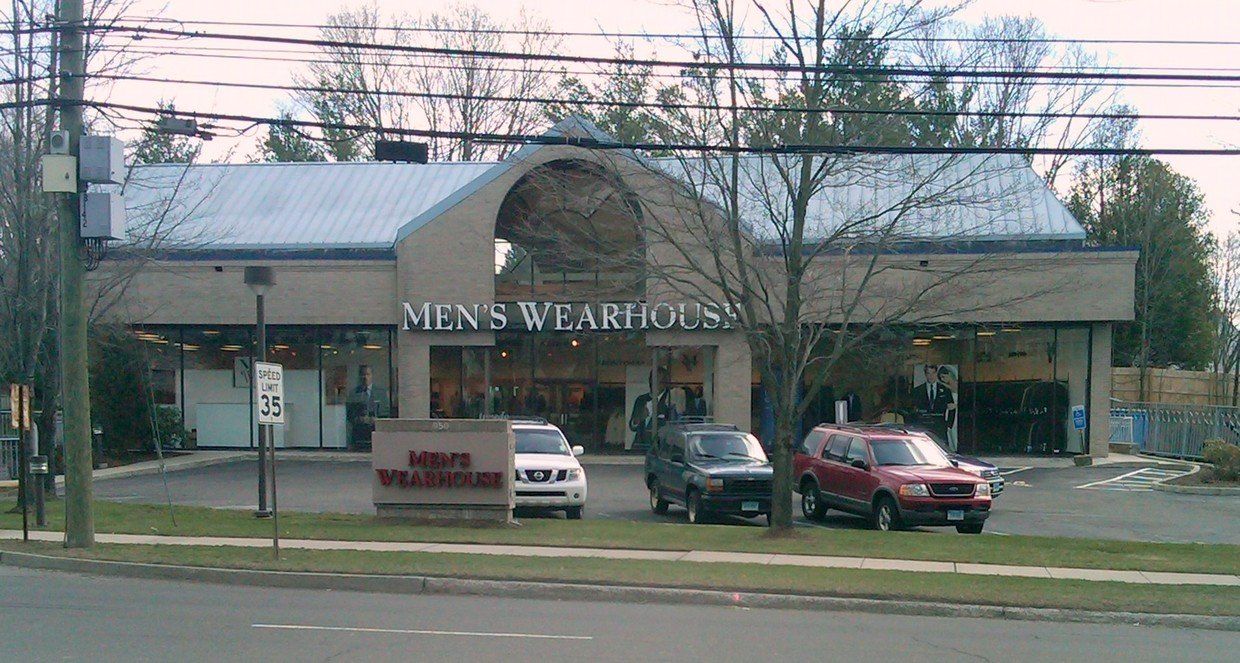 a men's wearhouse store with cars parked in front of it