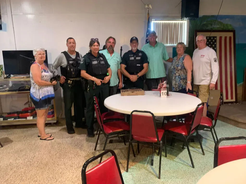 A group of people standing around a table in a room.