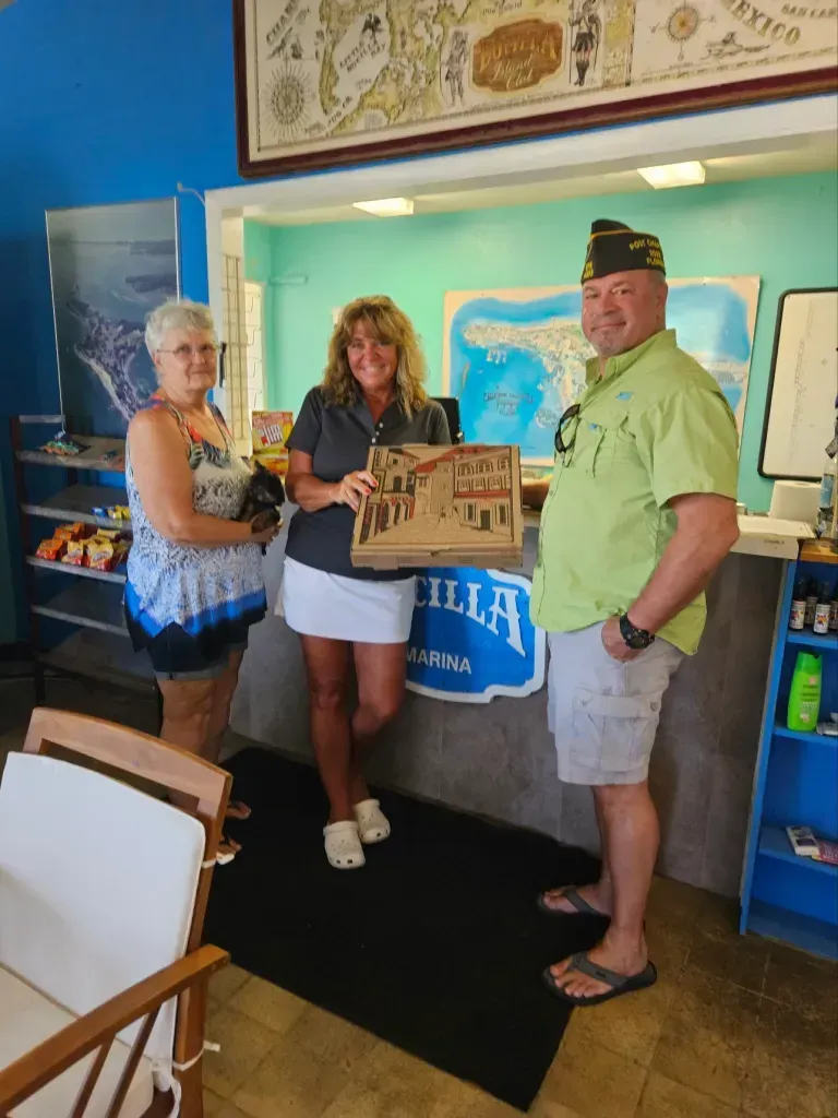 A man in a green shirt is standing next to two women