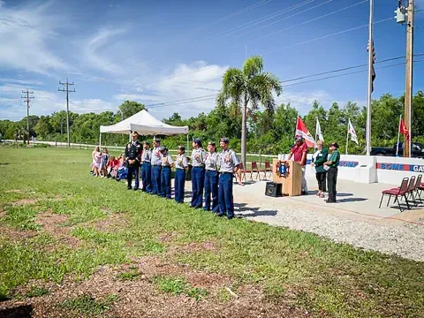 A group of people in military uniforms are standing in a field.