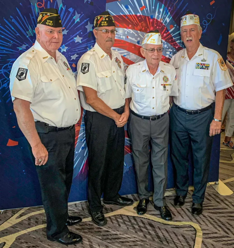 A group of men standing in front of an american flag