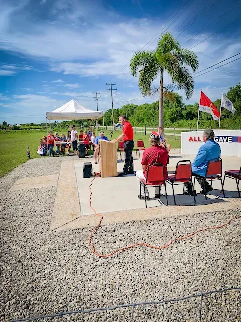 A man stands at a podium giving a speech to a group of people