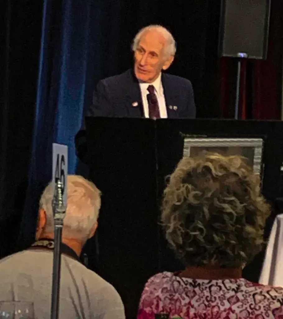 A man in a suit and tie is giving a speech