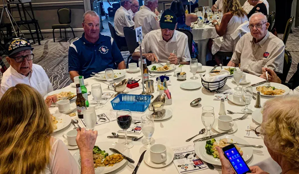 A group of people are sitting at a table with plates of food.