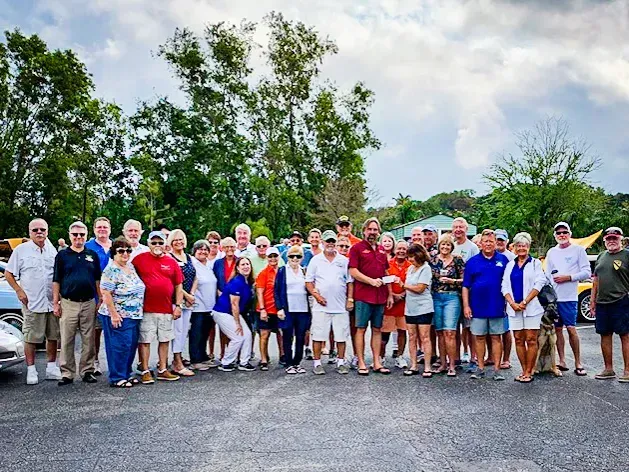 A large group of people are standing in a parking lot.