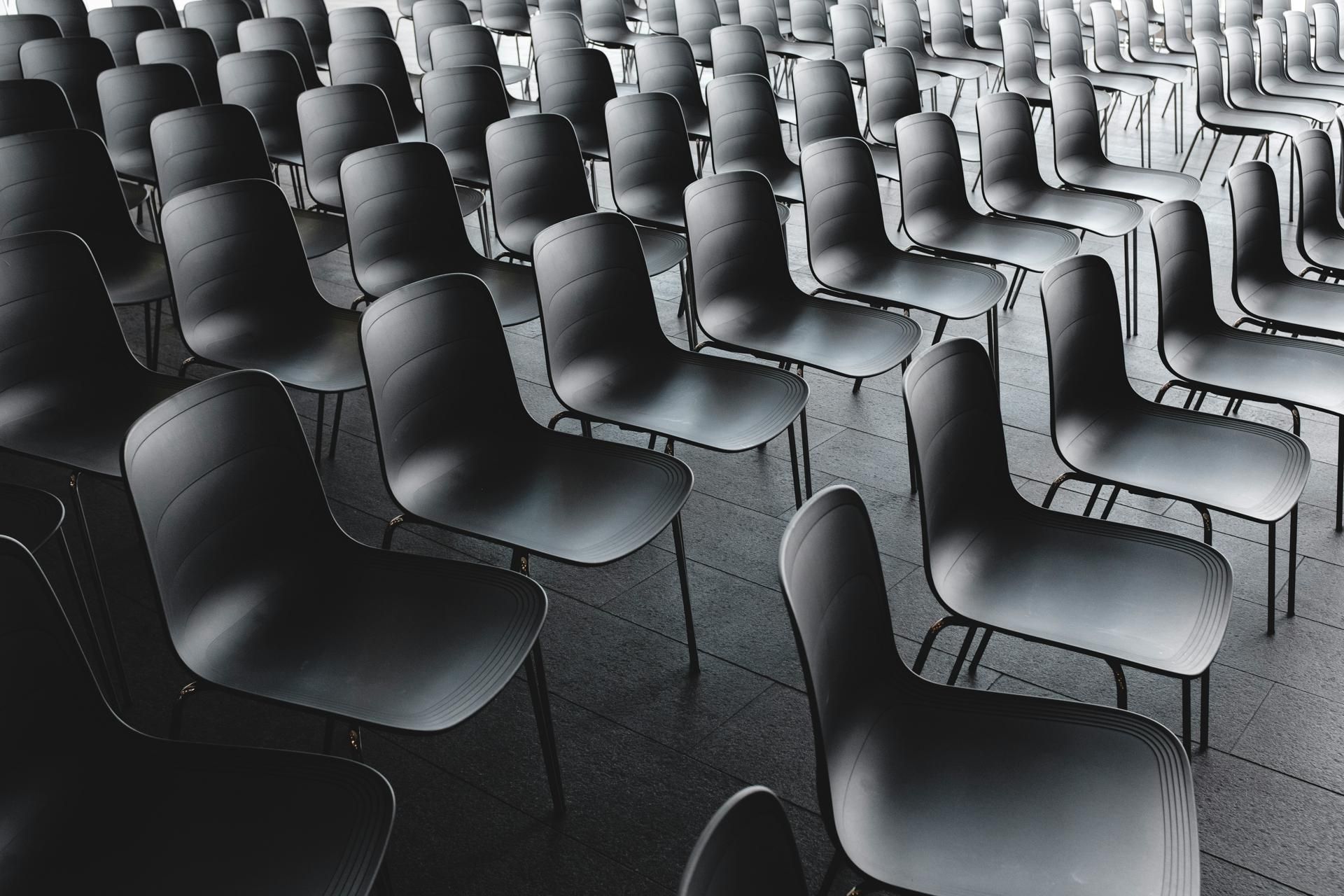 Viele schwarze Konferenzstühle in einem Saal