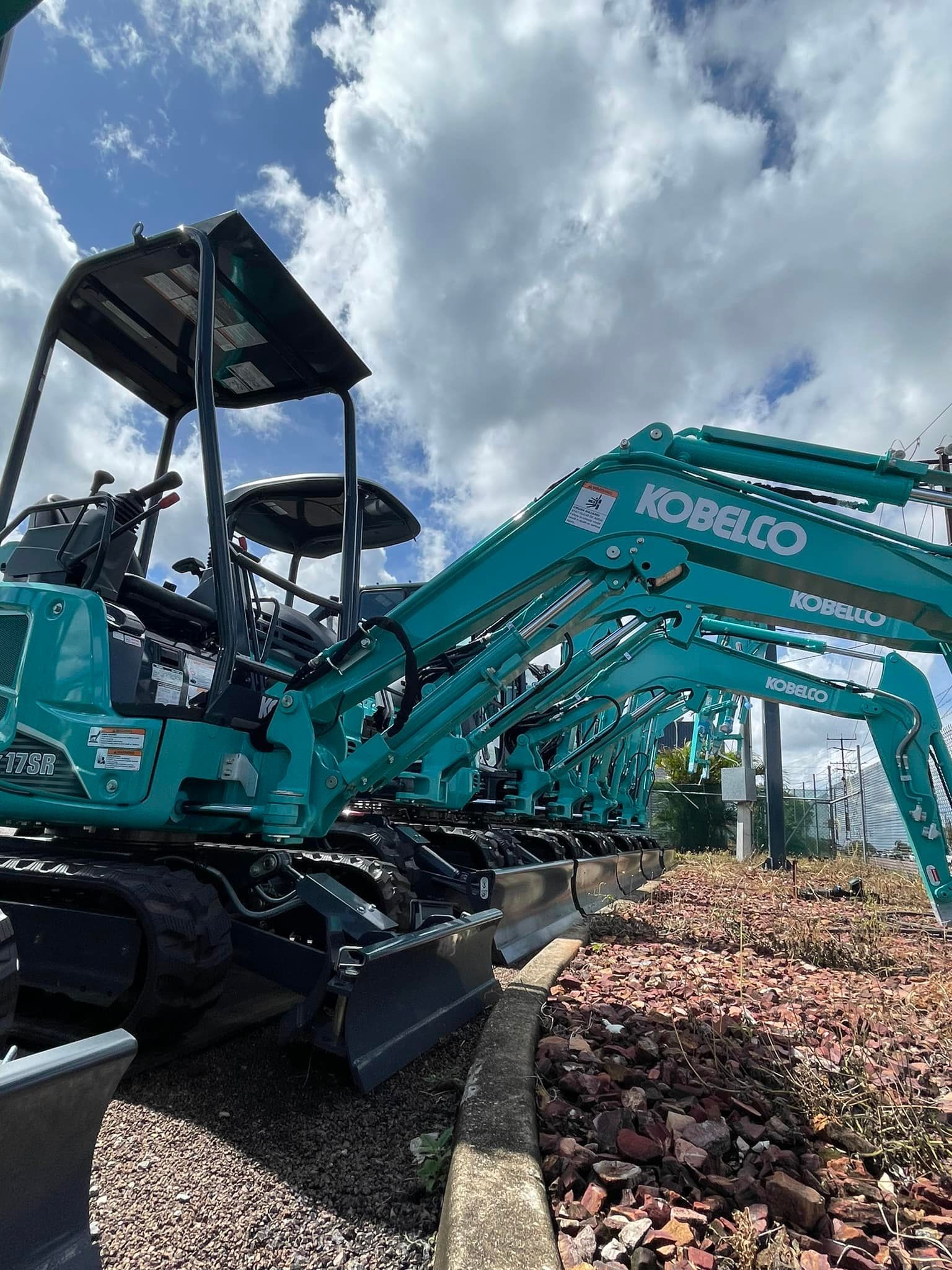 Teal Kobelco Excavator Parked Outside on A Cloudy Day — Forecast Machinery in Yarrawonga, NT