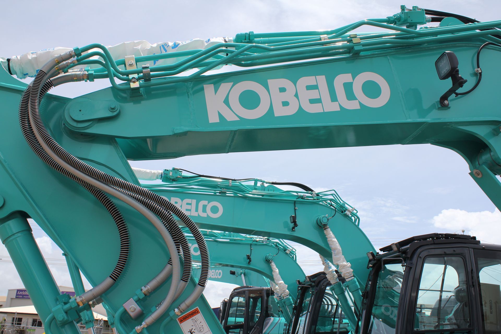 Teal Kobelco excavator on tracks, bucket extended. Black cab, white logo — Forecast Machinery in Yarrawonga, NT