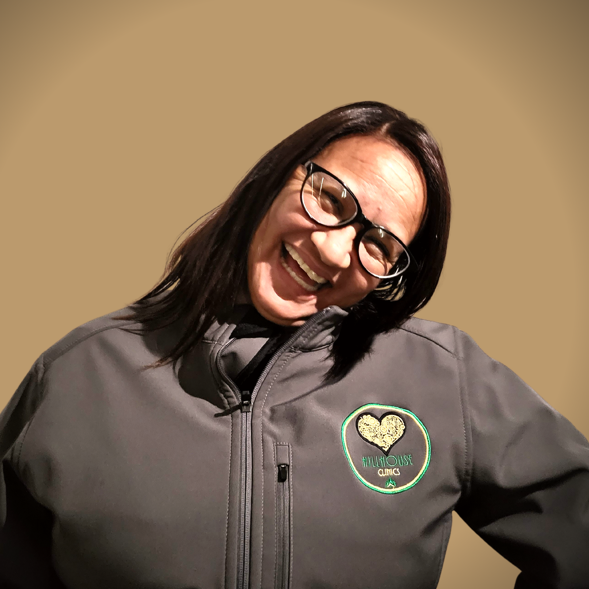 Een vrouw met een bril en een jas met een hart erop