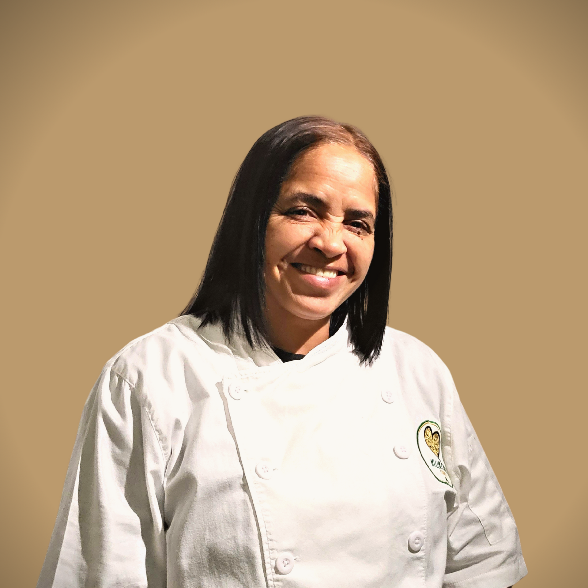 Een vrouw in een koksbuis lacht naar de camera.