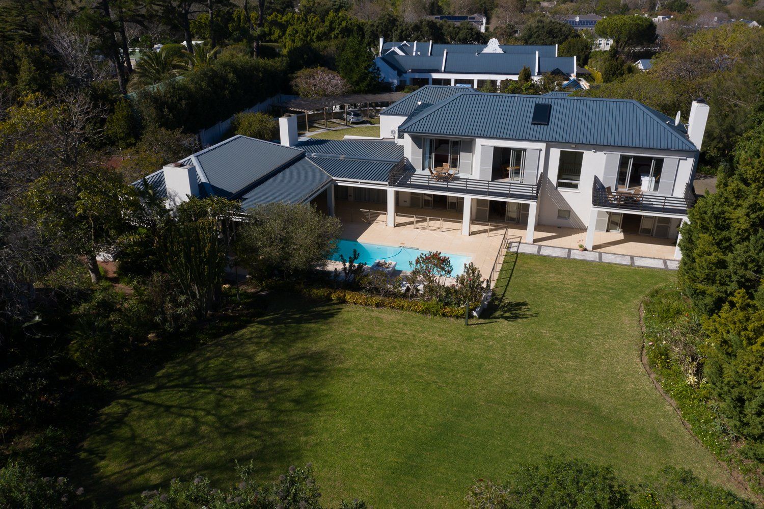 Een luchtfoto van een groot huis met een zwembad in de achtertuin.
